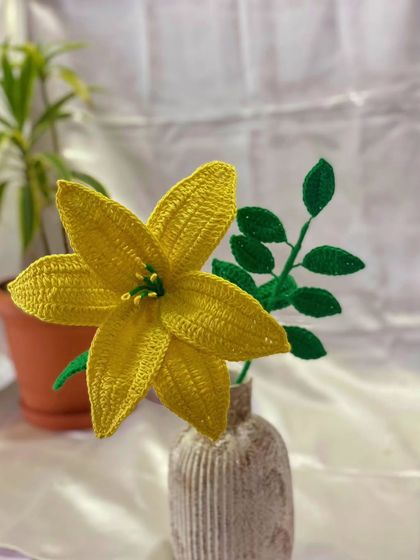 This single yellow lily is designed to be a bright and elegant piece of decor. Placed in a small vase, it adds a touch of handmade charm to any desk or shelf.