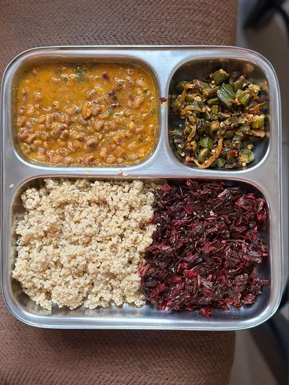 A plate with foxtail millet, black-eyed pea curry, and sautéed amaranth leaves and okra. This meal is a powerhouse of nutrients, including iron and fiber.