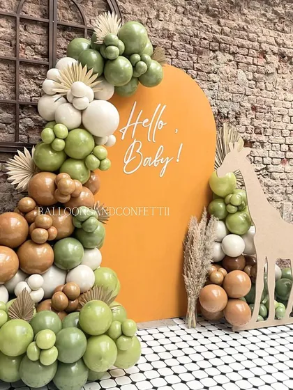 Hello, Baby! A unique and stylish jungle-themed baby welcome setup. The earthy green and brown balloons, giraffe cutout, and pampas grass create a warm, safari-inspired vibe.