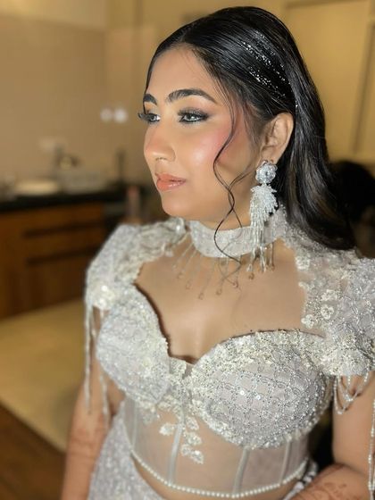 Serving ice queen vibes for a cocktail night. This look features a cool-toned smokey eye, sharp contour, and a wet-look hairstyle with tinsel for that extra sparkle.