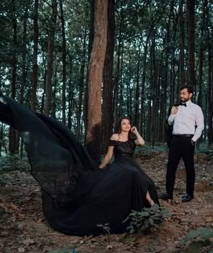 The flowing black trail gown adds a sense of movement and elegance to this enchanting forest pre-wedding shoot. It's a versatile piece for creating both dramatic and delicate looks.