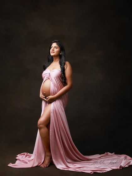 A powerful standing pose in a draped pink satin gown, looking upwards with a sense of strength and hope.