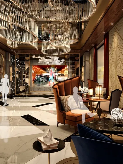 The lounge area of a luxury cinema, featuring plush high-back armchairs in rich jewel tones. The space is designed for comfort and sophistication, with dramatic chandeliers and marble accents creating an opulent pre-film experience.