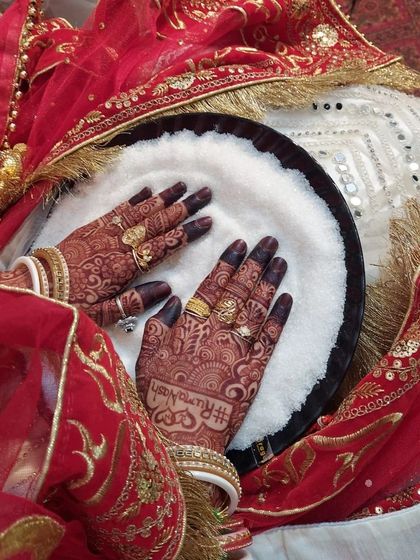 The bride's hands during a wedding ritual, with her custom hashtag design clearly visible. It's a modern twist on a timeless tradition.