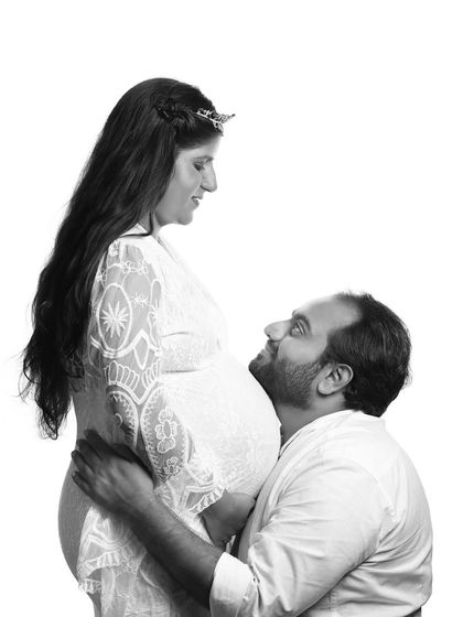 A loving gaze in black and white. The partner looks up at the mom-to-be with adoration, creating a photo that is full of emotion and tenderness.