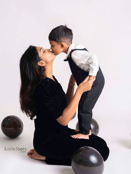 A sweet kiss from son to mom during his birthday photoshoot. This tender moment, captured amidst the celebration, is a memory to treasure.