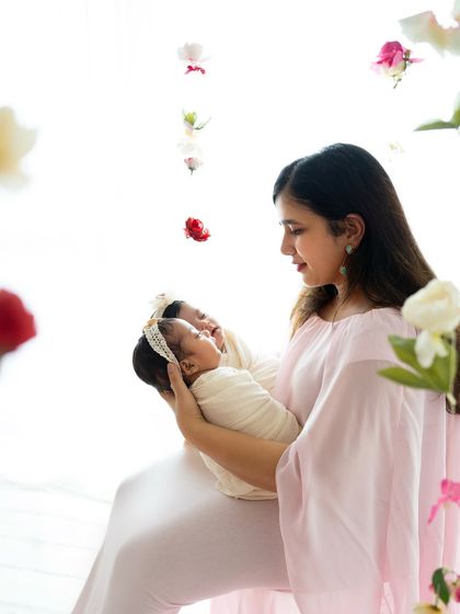 A mother's loving gaze as she holds her precious newborn twins. The soft lighting and floral details make this an absolutely dreamy portrait.