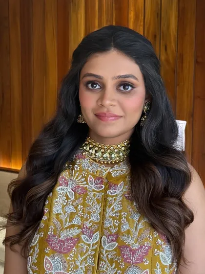 The mother-to-be looks radiant with her hair styled in a simple half-updo with voluminous waves, a comfortable and elegant choice for her celebration.