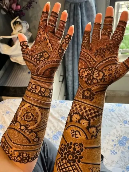 A full-arm design with a mix of traditional patterns, including the Om symbol.