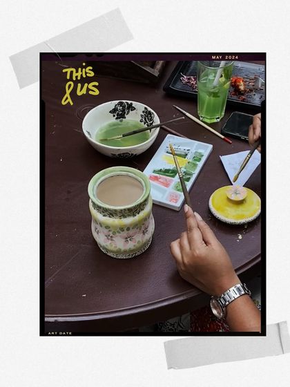 An art date in progress, with watercolors, brushes, and a cup of matcha on the table.