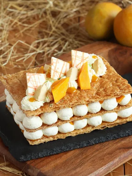A full view of our irresistible Mango Mille-feuille, with its flaky layers, cream, and tropical mango topping.