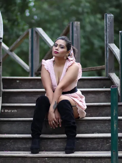 A seated portrait on wooden steps, with a strong and direct gaze.
