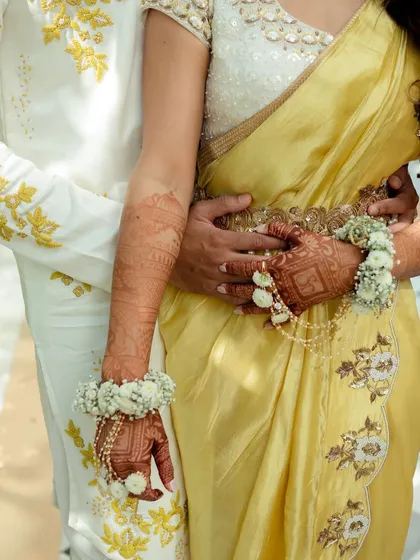 A close-up of the couple's hands, adorned with mehendi and floral jewelry. We focus on the beautiful details that make each ceremony unique.