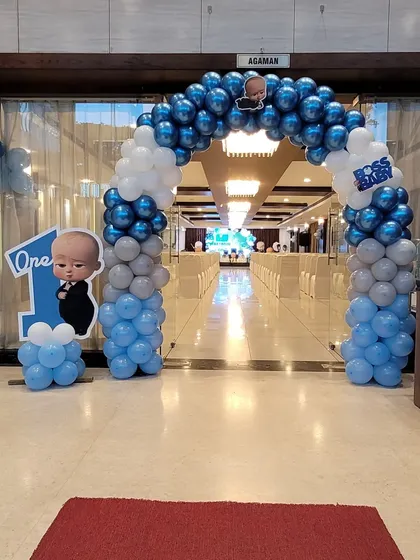 The entrance to the Boss Baby party, featuring a balloon arch in blue, white, and grey. A character cutout and a 'One' sign greet guests as they arrive.