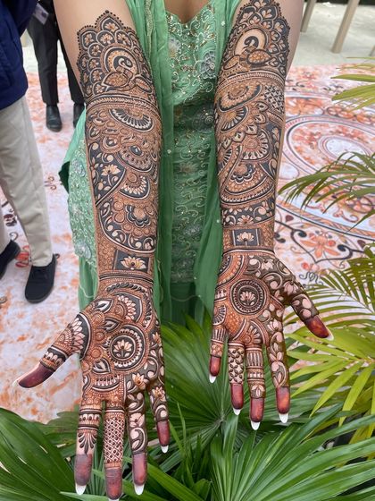 The complete bridal look, with full-sleeve mehandi featuring peacocks and mandalas.
