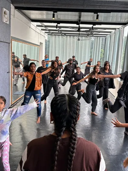 A view from behind, showing a class full of students learning and moving in sync.
