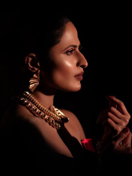 A profile shot that uses dramatic side lighting to create a mysterious and captivating mood. This technique highlights the model's silhouette and the texture of her hair and makeup.