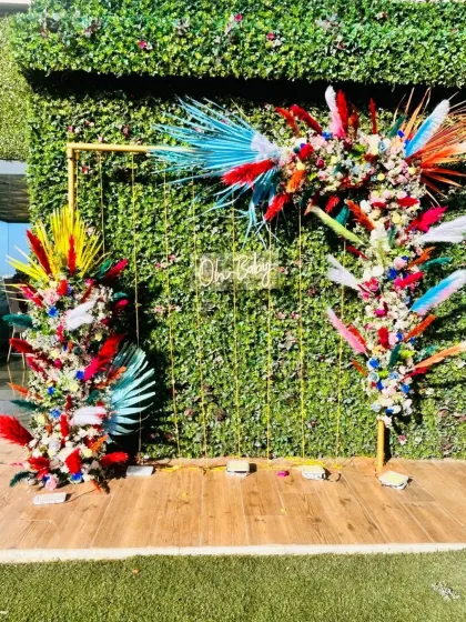 A vibrant and colorful floral backdrop with a neon sign, perfect for a lively and festive baby shower or birthday party.