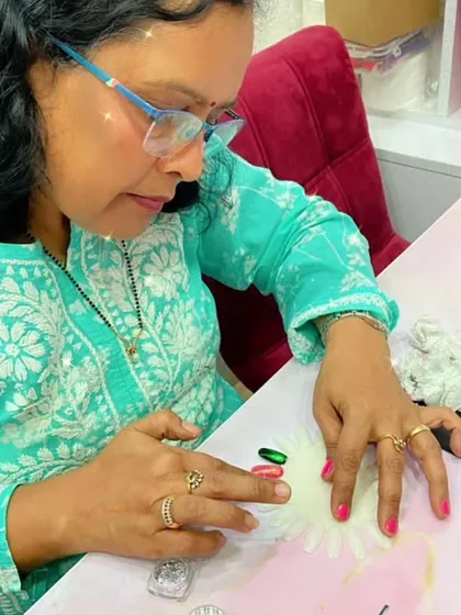 A student practices her nail art on a color wheel, a great way to experiment with different designs and colors.
