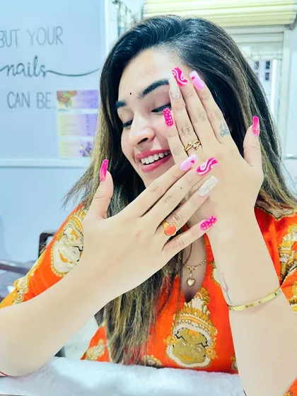 A happy client admiring her fun and colorful pink abstract nails. The smile says it all.