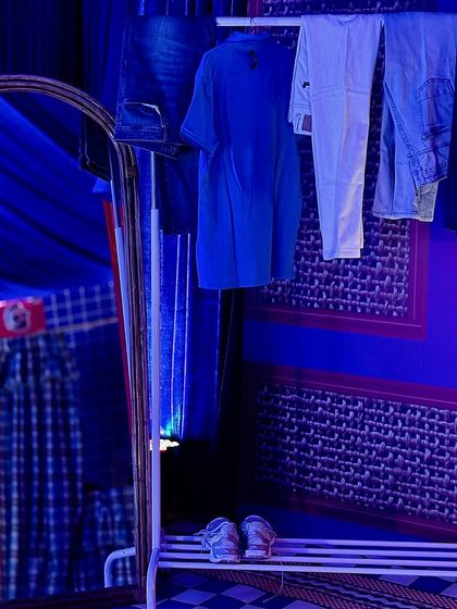 A clothing rack with outfits laid out, adding to the immersive 'sleepover' feel of the event.