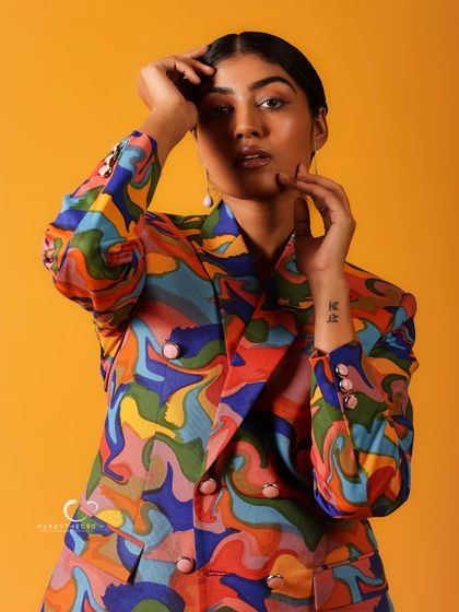 A portrait that is a true explosion of color. The psychedelic pattern of the suit against the yellow background is a feast for the eyes, celebrating bold self-expression.