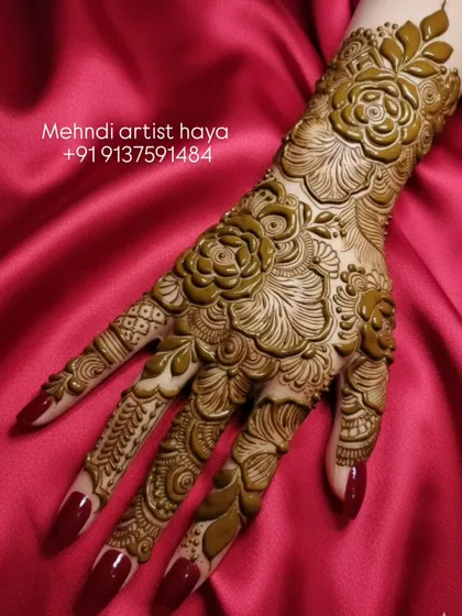 I love creating designs that pop. This full-hand bridal piece uses bold rose motifs with heavy shading, giving the henna a raised, almost carved appearance against the skin. It’s a statement piece for your big day.