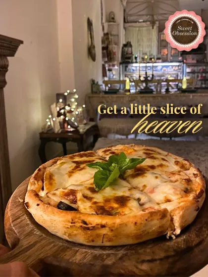 While we're known for our sweets, our savory menu is just as heartfelt. This wood-fired pizza, with its perfectly melted cheese and fresh toppings, is a slice of heavenly comfort, especially on a cozy evening.