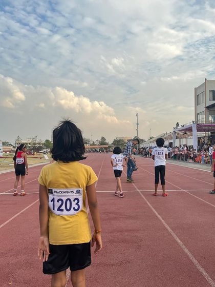 A young athlete waits for her turn on the track, embodying the commendable spirit of our competitors.