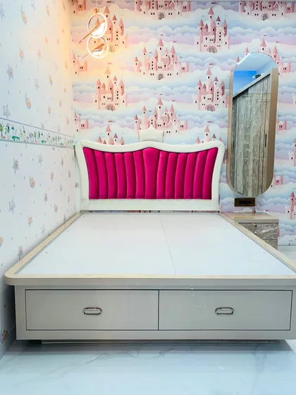 A full view of the princess-themed bed with a striking pink velvet headboard and a low-profile frame that includes two large pull-out drawers for toys or linens.