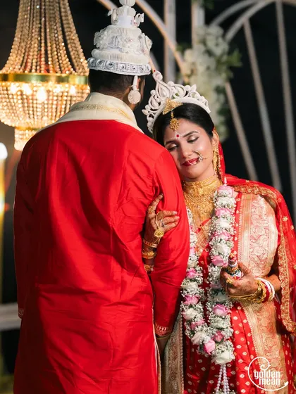 A tender moment between a Bengali bride and groom after their ceremony.