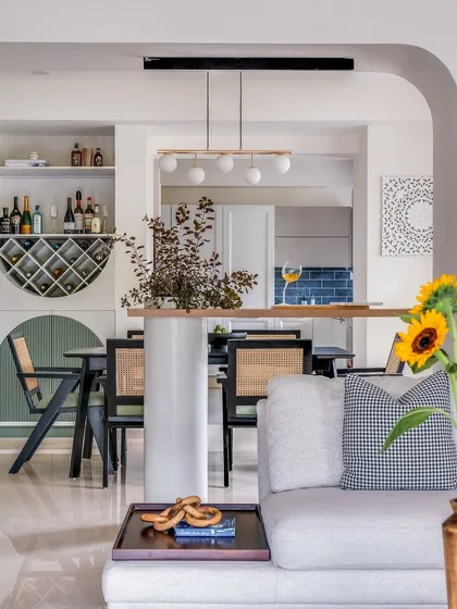 For this open-plan home, creating a sense of connection was key. I designed a breakfast bar that acts as a gentle partition between the living and dining areas, perfect for casual meals or conversations. The space is filled with natural light and thoughtful details like a custom wine rack and contemporary chairs, making it ideal for hosting friends and family.