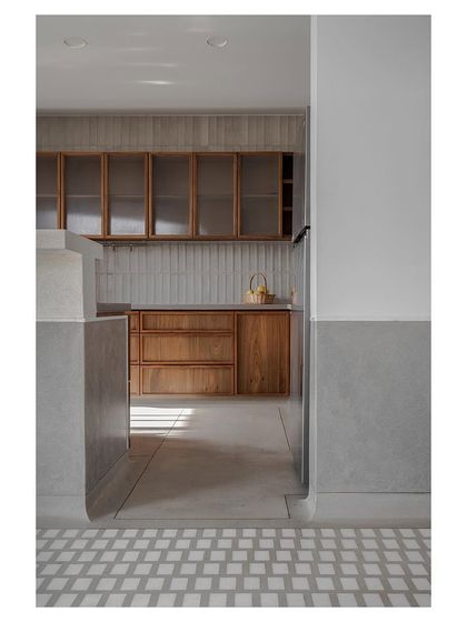 A view into a kitchen with custom teak cabinetry and handmade wall tiles, showcasing the beauty of natural materials and craftsmanship.