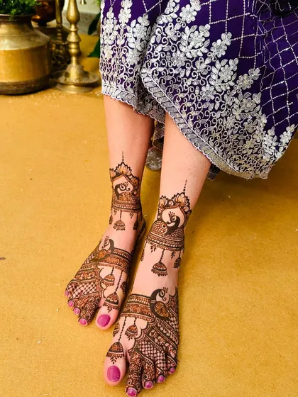 This foot mehndi showcases graceful peacocks and hanging jhumka motifs, creating a design that is both traditional and full of movement.