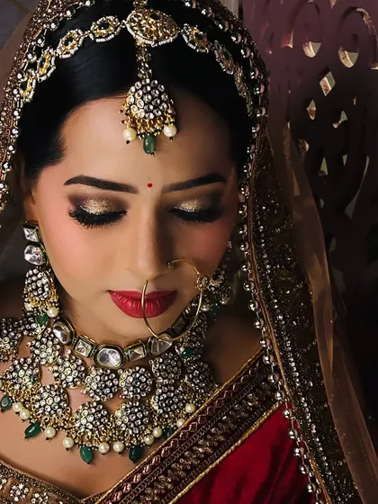 A close up of this bride's beautiful makeup. The golden glittery eyes and red lips are a perfect combination for a grand bridal look.