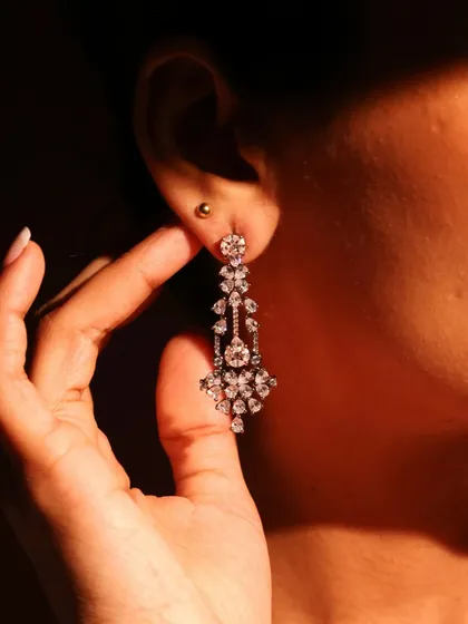 A model wearing the fancy-cut diamond earrings from the black rhodium set. The dramatic lighting emphasizes their unique sparkle and sophisticated design.