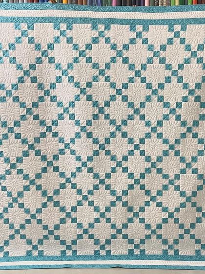 A classic 9-patch quilt in a refreshing teal and white, with a simple border.