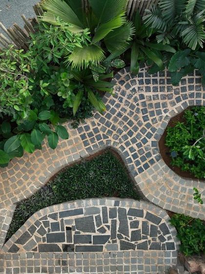 An aerial view of the freestyle patterned stone flooring at Sanctuary Bar. The organic pathways curve around pockets of greenery, creating a visually dynamic and sensory walking experience.