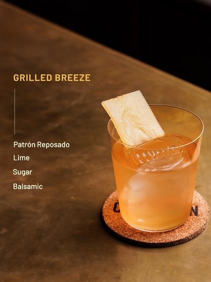 The Grilled Breeze, a smoky and citrusy cocktail from our limited-edition Bacardi menu. It features Patrón Reposado, lime, sugar, and a hint of balsamic.