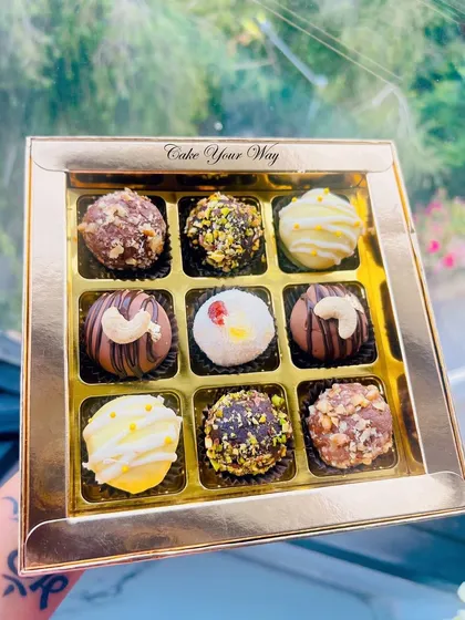 Take a closer look at my assorted handcrafted truffles. This box features a variety of flavors, from rich chocolate and nutty pistachio to zesty lemon, each one made with premium ingredients. They are a luxurious treat for any occasion.