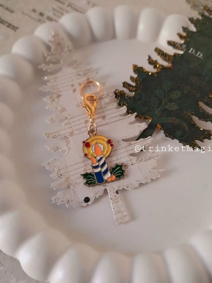 The Christmas candle charm displayed on a festive background, highlighting its warm and cozy vibe.