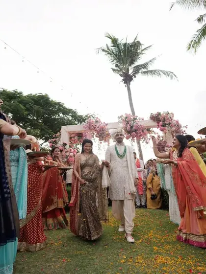 A closer look at the coordinated welcome for the groom, with family members holding plates of flowers, adding to the festive and traditional atmosphere.
