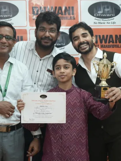 A student receives a large trophy from our teachers for his exceptional performance.