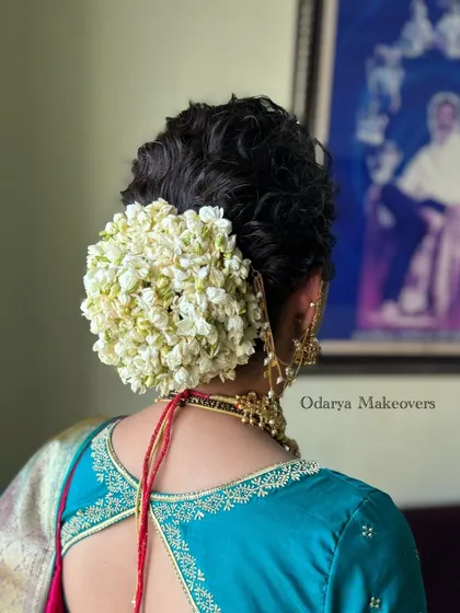 A classic bridal bun completely covered in fresh jasmine (mogra). This timeless and fragrant hairstyle is a favorite among Maharashtrian and South Indian brides.