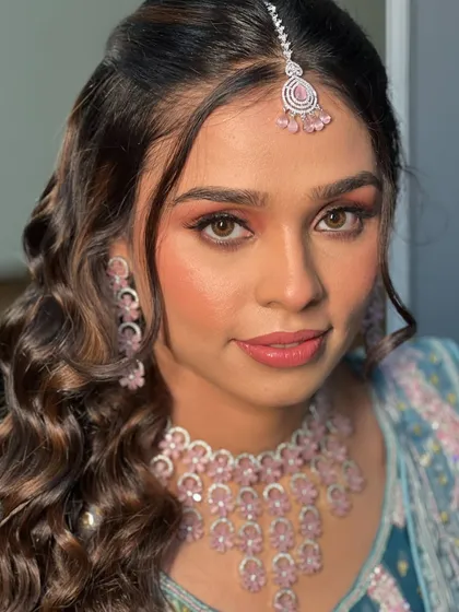 A close-up of Ayushi's engagement makeup, featuring soft peach tones on the eyes and cheeks.