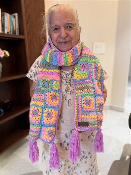 For those who love pastel colors, this granny square muffler is a dream. The soft shades of pink, blue, yellow, and purple create a gentle, pretty look, completed with lilac tassels.