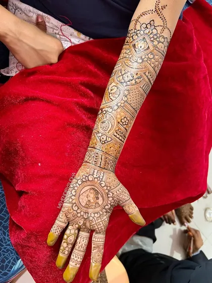 This design for Sonali features a lovely portrait of her within a circular frame on the palm, a classic and elegant way to personalize bridal henna.