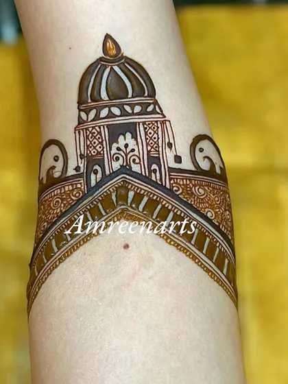 A simple yet striking arm band design featuring a palace dome and elephant motifs.