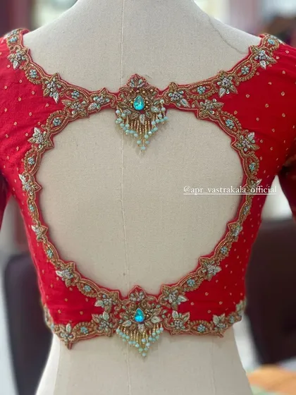The craftsmanship of the heart-shaped cutout is evident in this close-up, showing the delicate beadwork and fine embroidery.