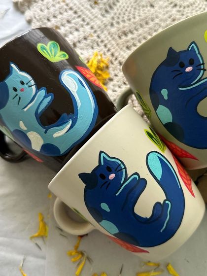 A set of three mugs featuring a cute, stylized blue cat design. Perfect for all the cat lovers out there.